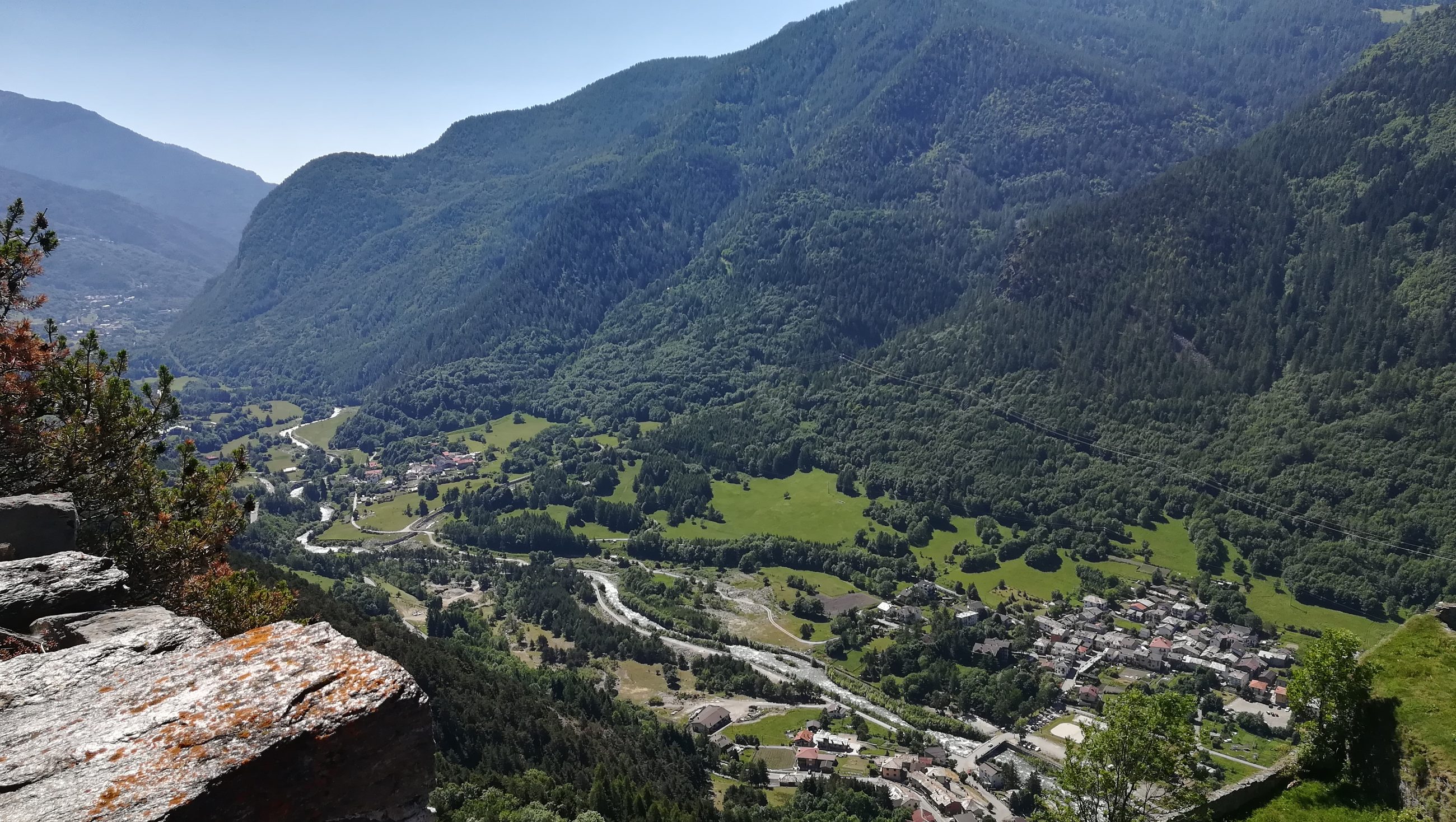 Veduta del fondovalle con borgo, prati e fiume